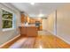 Open kitchen and dining area with wooden cabinets, wood floors, and views of a lush yard at 12046 Se 135Th Ave, Ocklawaha, FL 32179