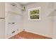 Bright laundry room featuring wire shelving, tiled floors and a window for natural light at 12046 Se 135Th Ave, Ocklawaha, FL 32179