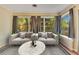 Comfortable sunroom with large windows and neutral-toned modern furniture at 12046 Se 135Th Ave, Ocklawaha, FL 32179