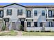 Modern townhome exterior with neutral paint, black iron gates, and well maintained front lawn and professional landscaping at 123 Kenny Blvd, Haines City, FL 33844
