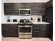 Modern kitchen with stainless steel appliances and dark wood cabinets at 123 Kenny Blvd, Haines City, FL 33844