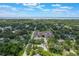 Scenic aerial view of a neighborhood filled with mature trees, featuring a prominent building and a glimpse of the distant waterway at 1505 Magnolia Ave, Sanford, FL 32771
