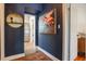 Stylish hallway features dark blue walls, colorful artwork, white trim, and access to the kitchen at 1505 Magnolia Ave, Sanford, FL 32771