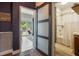Hallway featuring modern sliding doors accessing a bathroom and backyard, stylish decor, and wood floors at 1505 Magnolia Ave, Sanford, FL 32771