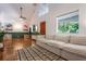 Open-concept living room with hardwood floors, large windows, and a comfortable neutral sectional sofa at 1505 Magnolia Ave, Sanford, FL 32771