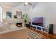 Bright living room features a cozy fireplace, hardwood floors, and modern entertainment center at 1505 Magnolia Ave, Sanford, FL 32771