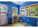 Bright sunroom with blue walls, lots of natural light, and view of the well maintained yard at 1505 Magnolia Ave, Sanford, FL 32771
