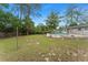 Spacious backyard featuring a round pool with deck, mature trees, and a partial wooden fence at 16 Lake Drive, Debary, FL 32713
