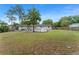 Expansive backyard with a pool, storage tanks, partial wooden fence, and back view of home at 16 Lake Drive, Debary, FL 32713
