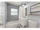 This bathroom offers a tub with gray tiling and a stylish single sink vanity at 16 Lake Drive, Debary, FL 32713