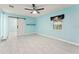Comfortable bedroom boasts sleek tile floors, a modern ceiling fan and a sliding barn door at 16 Lake Drive, Debary, FL 32713
