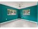 A bright bedroom featuring two windows, modern ceiling fan, and stylish gray floors at 16 Lake Drive, Debary, FL 32713