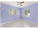 A sunlit bedroom with neutral floors features two windows and a ceiling fan at 16 Lake Drive, Debary, FL 32713
