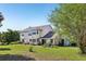 Spacious backyard with a view of the rear of the two-story residence and patio at 16249 Se 162Nd Ct, Weirsdale, FL 32195
