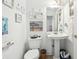 Cozy bathroom with pedestal sink, toilet, and decorative beach-themed accents at 16249 Se 162Nd Ct, Weirsdale, FL 32195