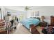Bright bedroom featuring a queen bed, ceiling fan, and natural light from two windows at 16249 Se 162Nd Ct, Weirsdale, FL 32195