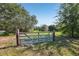Gated entrance to lush green lot with a peaceful, serene atmosphere at 16249 Se 162Nd Ct, Weirsdale, FL 32195