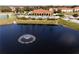 Aerial perspective of a community featuring a pool and clubhouse, complemented by a scenic pond with a fountain at 1800 Coriander Dr, Kissimmee, FL 34759