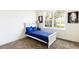Bright bedroom with a white bed frame, blue comforter, and serene outdoor view from a large window at 1800 Coriander Dr, Kissimmee, FL 34759