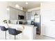 Modern kitchen with gray cabinets, granite countertops, stainless steel appliances, and breakfast bar seating at 1800 Coriander Dr, Kissimmee, FL 34759