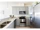 Bright kitchen with stainless steel appliances, gray cabinets, and granite countertops at 1800 Coriander Dr, Kissimmee, FL 34759