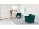 Bright seating area with decorative emerald chairs, round table and neutral-colored walls and flooring at 1800 Coriander Dr, Kissimmee, FL 34759