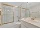 Bathroom featuring a toilet, vanity and tub with sliding glass doors at 200 Maitland Ave # 122, Altamonte Springs, FL 32701