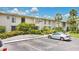 Exterior of a condo complex with lush landscaping, reserved parking, and sunny sky at 200 Maitland Ave # 122, Altamonte Springs, FL 32701
