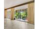 Living room featuring tile floors and a view of the trees through the windows and sliding doors at 200 Maitland Ave # 122, Altamonte Springs, FL 32701
