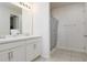Bright bathroom featuring double sinks, white cabinets, and a shower with a patterned curtain at 200 Summershore Dr, Auburndale, FL 33823