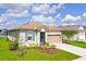 Attractive single-Gathering home displaying a two car garage, pretty landscaping and manicured lawn at 200 Summershore Dr, Auburndale, FL 33823