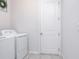 Laundry room with a white washer and dryer and a white door at 200 Summershore Dr, Auburndale, FL 33823