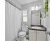 Well-lit bathroom featuring a shower with curtain, toilet, and vanity with sink at 202 Twisting Trl, Orlando, FL 32825