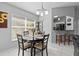 Bright dining area with views to kitchen and backyard, complemented by tiled floors and modern lighting at 202 Twisting Trl, Orlando, FL 32825