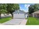 Detached garage and driveway, with green lawn and mature trees, providing ample parking at 202 Twisting Trl, Orlando, FL 32825