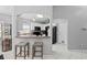 Open kitchen area featuring breakfast bar with modern stools, white cabinets, and stainless appliances at 202 Twisting Trl, Orlando, FL 32825