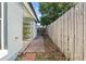 Side yard with brick path and potting shelves against the house at 202 Twisting Trl, Orlando, FL 32825
