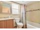 Well-lit bathroom featuring granite countertop, wood cabinets, and a shower-tub combo at 20330 Majestic St, Orlando, FL 32833