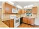 Well-lit kitchen with wood cabinets, granite countertops, tiled backsplash, and modern appliances at 20330 Majestic St, Orlando, FL 32833