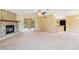Open-concept living area with a stone fireplace, neutral carpeting, and a view into the kitchen at 20330 Majestic St, Orlando, FL 32833