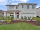 Charming two-story home with manicured lawn, neutral colors, and inviting front porch at 2111 Greenwood Oak Dr, Ocoee, FL 34761