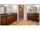 Bathroom featuring dual sinks, wood cabinets, and a glass shower enclosure with tiled walls at 2305 Edgewater Dr # 1509, Orlando, FL 32804