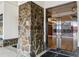 Building entrance with stone accent wall and glass door at 2305 Edgewater Dr # 1509, Orlando, FL 32804