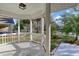 Covered porch with tiled flooring, offering views of the surrounding lush yard and palm trees at 25 Reflections Village Dr, Ormond Beach, FL 32174