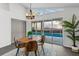 Dining area with pool view, modern light fixture, and seating for four at 25 Reflections Village Dr, Ormond Beach, FL 32174