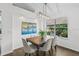 Charming dining room with hardwood floors, modern lighting, and a view of lush greenery at 25 Reflections Village Dr, Ormond Beach, FL 32174