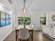 Elegant dining room with hardwood floors, a modern chandelier, and a view of mature landscaping at 25 Reflections Village Dr, Ormond Beach, FL 32174