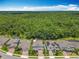 An aerial view showcases homes in a lush neighborhood with a beautiful forest backdrop at 2676 Estuary Loop, Oviedo, FL 32765