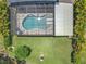 Aerial view of a screened in pool and patio with a spacious manicured lawn and tropical landscaping at 2676 Estuary Loop, Oviedo, FL 32765