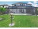 Spacious backyard with a screened-in pool, lush green lawn, and a charming bird feeder feature at 2676 Estuary Loop, Oviedo, FL 32765